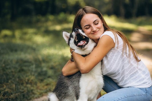 A girl hugging her dog in outdoor 