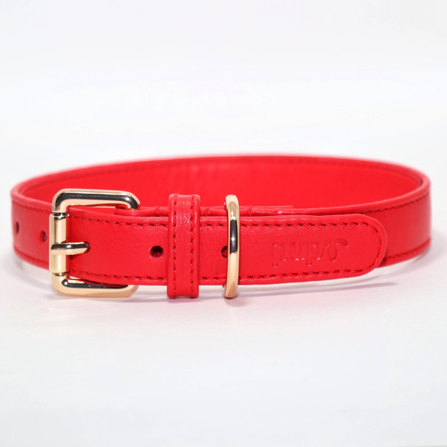 A red dog collar with a gold-colored metal buckle and ring.